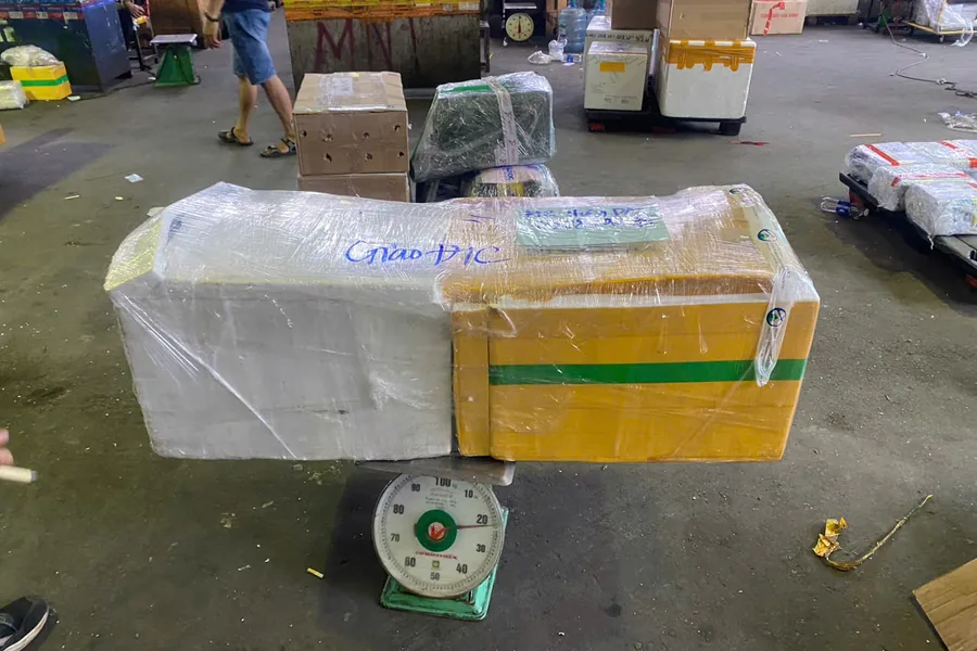 Kiện hàng được cân trước khi trao đổi phương án gửi.